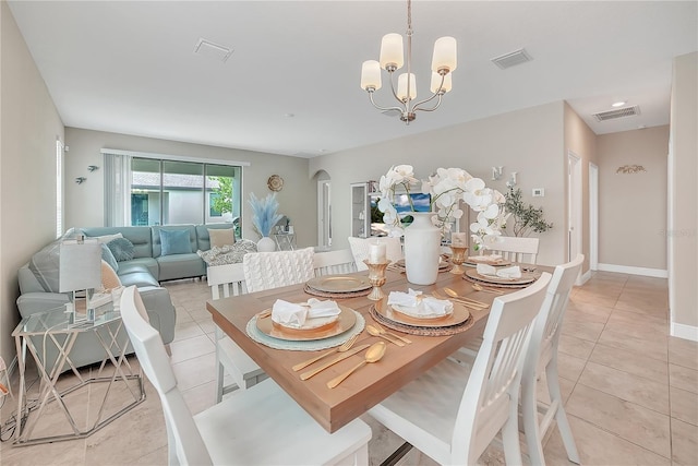 12591 Vander Way, New Port Richey, FL 34654 - dining room featuring light tile patterned floors, a chandelier, and arched walkways