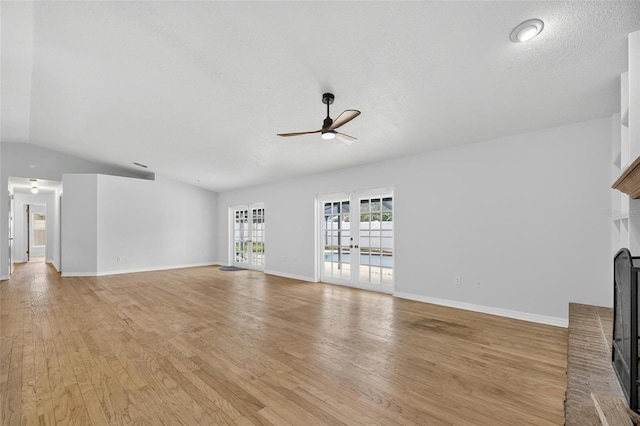 12331 Yellow Rose Cir, Riverview, FL 33569 - unfurnished living room with a fireplace, ceiling fan, light wood-style floors, vaulted ceiling, and french doors