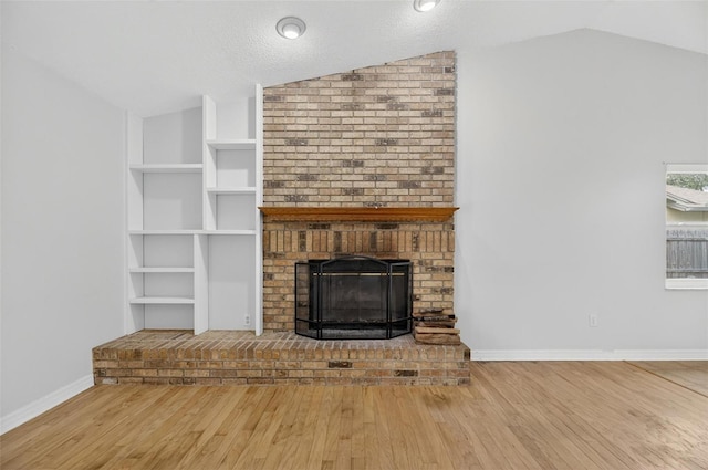 12331 Yellow Rose Cir, Riverview, FL 33569 - unfurnished living room with vaulted ceiling, a fireplace, and wood finished floors
