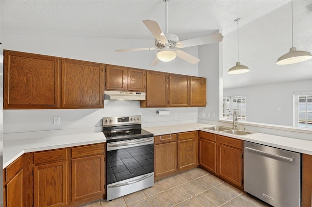 12331 Yellow Rose Cir, Riverview, FL 33569 - kitchen with stainless steel appliances, under cabinet range hood, light tile patterned floors, ceiling fan, and brown cabinetry