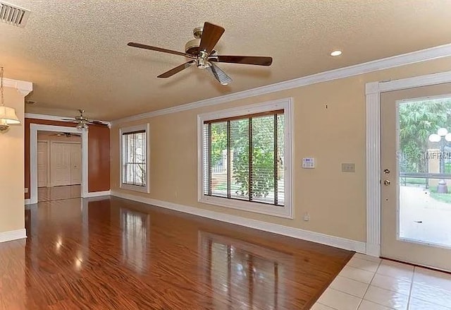 3411 Holland Dr, Brandon, FL 33511 - unfurnished living room featuring a ceiling fan, a textured ceiling, plenty of natural light, ornamental molding, and tile patterned flooring
