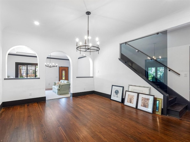 1570 48th Ave N, Saint Petersburg, FL 33703 - unfurnished living room with a chandelier, healthy amount of natural light, wood finished floors, arched walkways, and recessed lighting