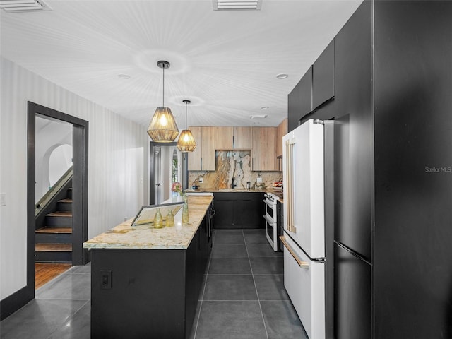 1570 48th Ave N, Saint Petersburg, FL 33703 - kitchen featuring a center island, white appliances, dark tile patterned flooring, dark cabinetry, and backsplash