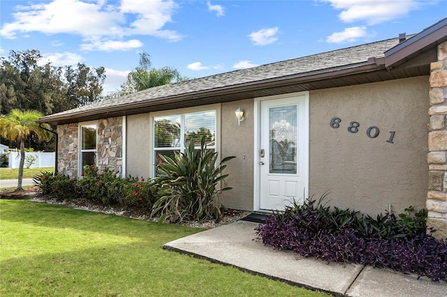 6801 34th Ave W, Bradenton, FL 34209 - property entrance featuring stucco siding, stone siding, and a yard