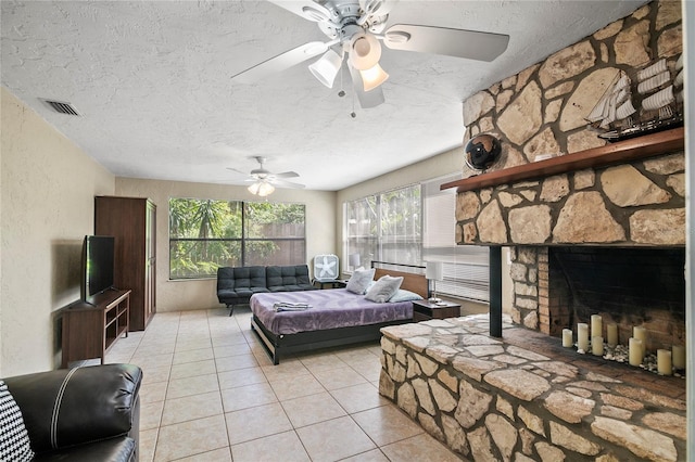 6801 34th Ave W, Bradenton, FL 34209 - living room with light tile patterned floors, a textured ceiling, a ceiling fan, healthy amount of natural light, and a stone fireplace