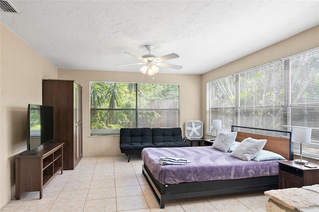 6801 34th Ave W, Bradenton, FL 34209 - bedroom featuring light tile patterned flooring, a textured ceiling, and a ceiling fan