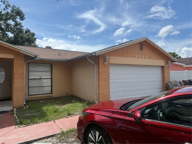 9705 Kingsburgh Ct, Tampa, FL 33615 - view of side of home with an attached garage, roof with shingles, and stucco siding
