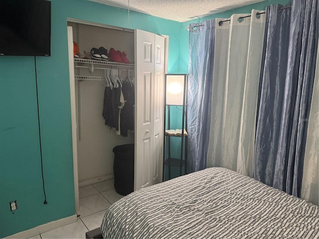 9705 Kingsburgh Ct, Tampa, FL 33615 - bedroom with a closet, a textured ceiling, and light tile patterned floors