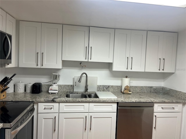 7518 Dolonita Dr Unit 7518, Tampa, FL 33615 - kitchen featuring dishwashing machine, black microwave, white cabinets, light stone counters, and stainless steel range with electric stovetop