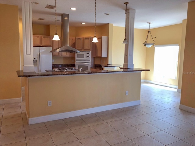 6517 Channelside Dr, New Port Richey, FL 34652 - kitchen with island range hood, white appliances, ornate columns, dark stone countertops, and light tile patterned flooring