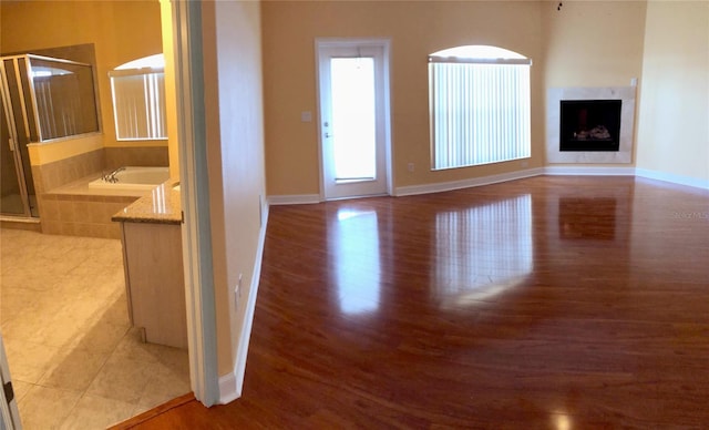 6517 Channelside Dr, New Port Richey, FL 34652 - unfurnished living room featuring light wood-type flooring and a high end fireplace