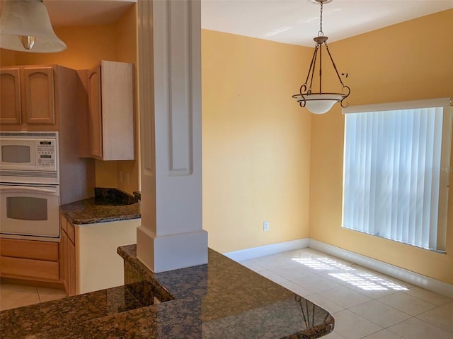 6517 Channelside Dr, New Port Richey, FL 34652 - kitchen with white appliances, light tile patterned floors, decorative light fixtures, and dark stone countertops