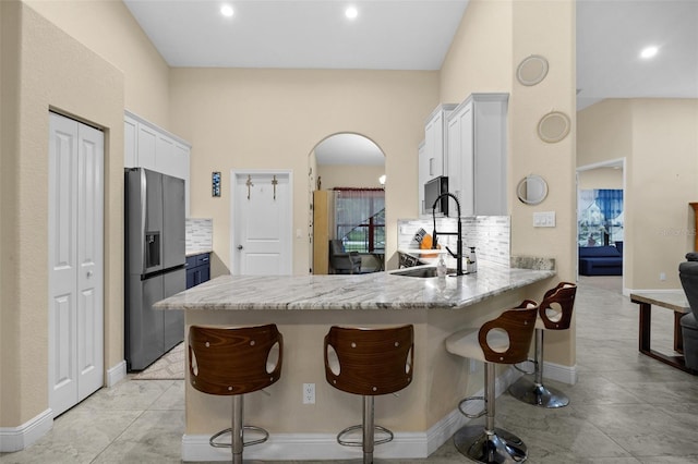 13395 59th Ct N, West Palm Beach, FL 33411 - kitchen with stainless steel refrigerator with ice dispenser, a peninsula, decorative backsplash, a kitchen bar, and recessed lighting