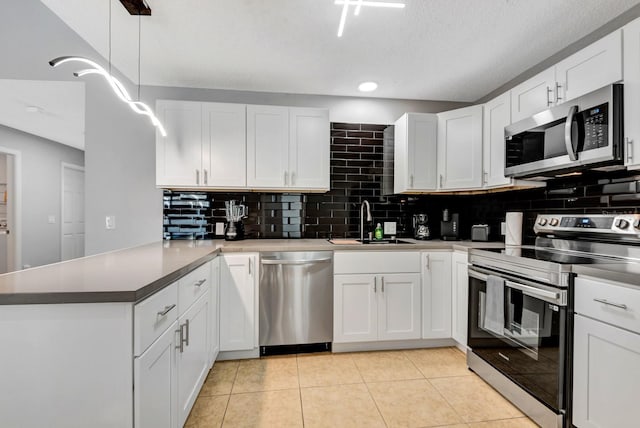 5682 25th Street Cir E, Bradenton, FL 34203 - kitchen with appliances with stainless steel finishes, a peninsula, backsplash, white cabinets, and recessed lighting