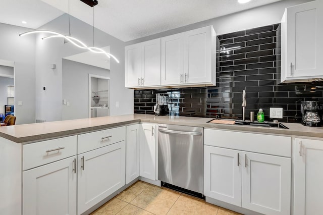 5682 25th Street Cir E, Bradenton, FL 34203 - kitchen with dishwasher, a peninsula, tasteful backsplash, white cabinets, and light tile patterned floors