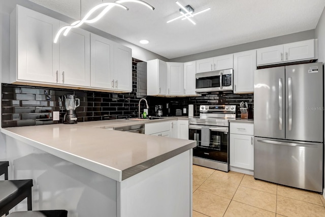 5682 25th Street Cir E, Bradenton, FL 34203 - kitchen featuring stainless steel appliances, a peninsula, decorative backsplash, white cabinets, and recessed lighting