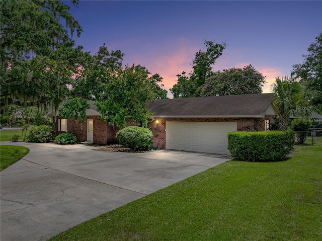 609 W Pipkin Rd, Lakeland, FL 33813 - view of front facade with concrete driveway, an attached garage, and brick siding