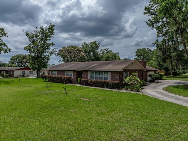 609 W Pipkin Rd, Lakeland, FL 33813 - single story home featuring concrete driveway, a front lawn, a garage, brick siding, and a chimney