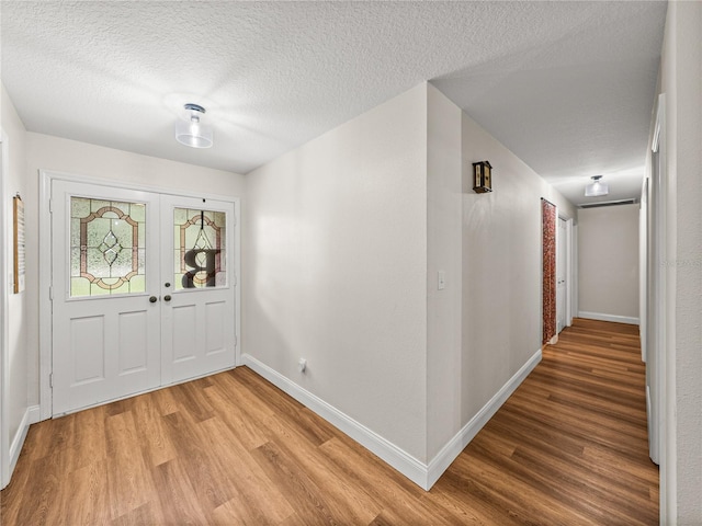 609 W Pipkin Rd, Lakeland, FL 33813 - foyer entrance with light wood-type flooring, a textured ceiling, and french doors