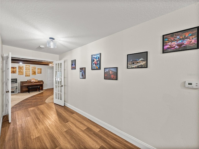 609 W Pipkin Rd, Lakeland, FL 33813 - hallway with french doors, wood finished floors, and a textured ceiling