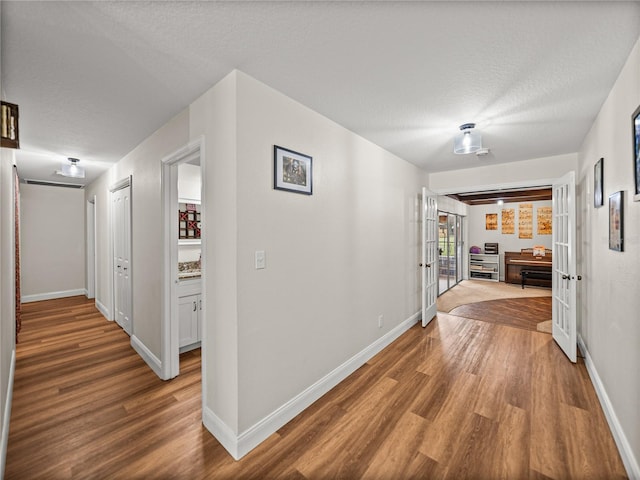 609 W Pipkin Rd, Lakeland, FL 33813 - hallway with french doors, wood finished floors, and a textured ceiling