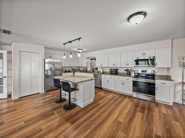 609 W Pipkin Rd, Lakeland, FL 33813 - kitchen with appliances with stainless steel finishes, dark wood-style flooring, and white cabinetry