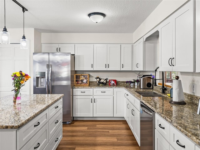 609 W Pipkin Rd, Lakeland, FL 33813 - kitchen with stainless steel appliances, white cabinetry, dark wood-style floors, light stone counters, and a textured ceiling