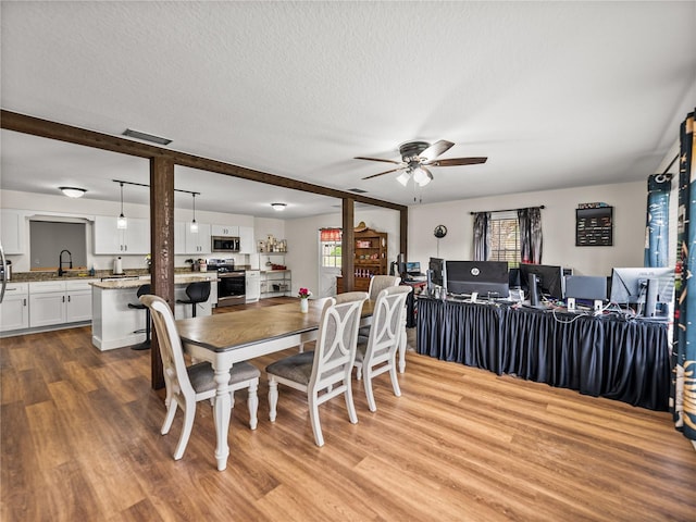 609 W Pipkin Rd, Lakeland, FL 33813 - dining area featuring ceiling fan, wood finished floors, and a textured ceiling