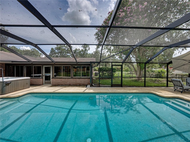 609 W Pipkin Rd, Lakeland, FL 33813 - outdoor pool featuring a patio, glass enclosure, and a hot tub