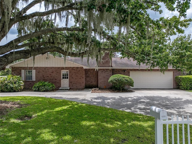 609 W Pipkin Rd, Lakeland, FL 33813 - view of front facade with driveway, brick siding, and a garage