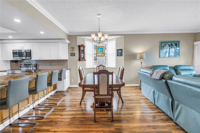 6399 Shoreline Dr Unit 4201, Saint Petersburg, FL 33708 - dining room featuring crown molding, a chandelier, wood finished floors, a textured ceiling, and recessed lighting
