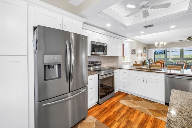 6399 Shoreline Dr Unit 4201, Saint Petersburg, FL 33708 - kitchen with appliances with stainless steel finishes, ceiling fan, light wood-style floors, crown molding, and white cabinets