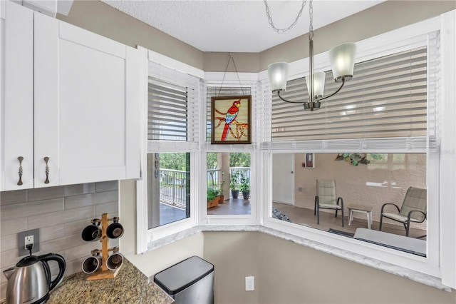 6399 Shoreline Dr Unit 4201, Saint Petersburg, FL 33708 - kitchen featuring white cabinets, backsplash, and a chandelier
