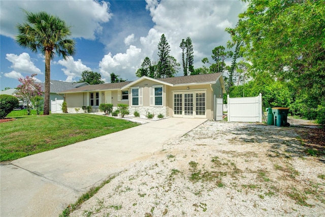 2442 Dando St, Port Charlotte, FL 33948 - single story home with stucco siding, driveway, stone siding, and french doors