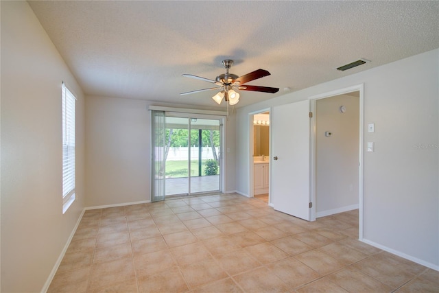 2442 Dando St, Port Charlotte, FL 33948 - empty room featuring a ceiling fan, a textured ceiling, and light tile patterned floors