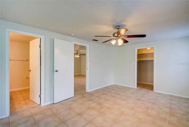 2442 Dando St, Port Charlotte, FL 33948 - unfurnished bedroom with a walk in closet, ceiling fan, connected bathroom, and light tile patterned flooring