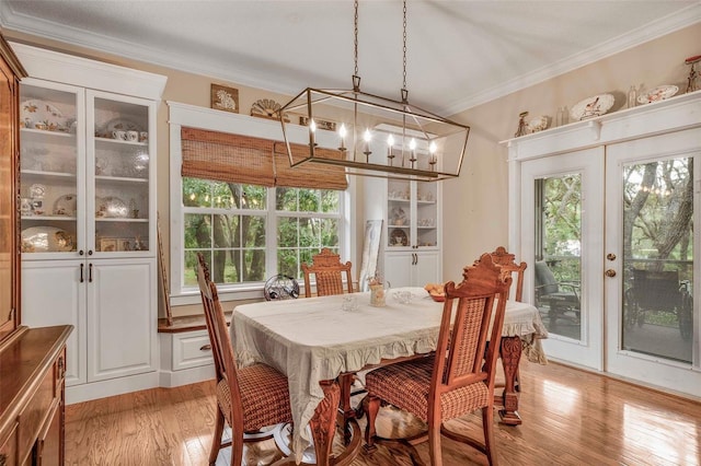 828 E Savoy St, Lecanto, FL 34461 - dining space featuring a chandelier, light wood-style flooring, and crown molding