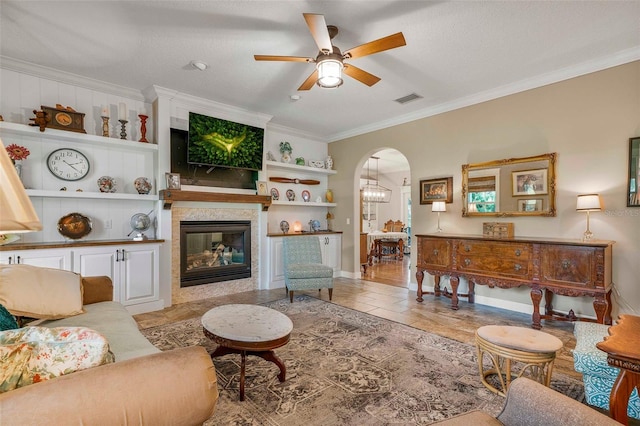 828 E Savoy St, Lecanto, FL 34461 - living area featuring a ceiling fan, ornamental molding, arched walkways, built in features, and a multi sided fireplace