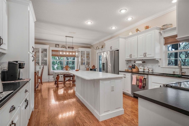 828 E Savoy St, Lecanto, FL 34461 - kitchen with appliances with stainless steel finishes, crown molding, white cabinets, dark countertops, and light wood-type flooring
