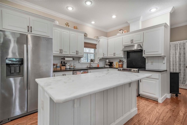 828 E Savoy St, Lecanto, FL 34461 - kitchen with stainless steel appliances, under cabinet range hood, light wood-style flooring, tasteful backsplash, and white cabinets