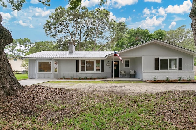 4233 Oak Ln, Saint Augustine, FL 32086 - ranch-style house with a chimney, a metal roof, a porch, and brick siding