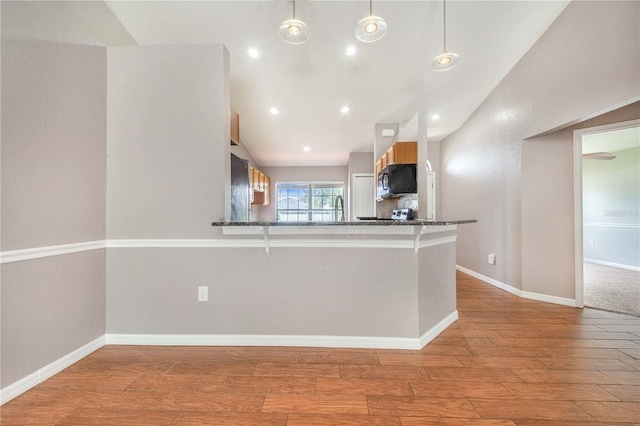 161 Oak Crossing Blvd, Auburndale, FL 33823 - kitchen with a kitchen breakfast bar, light wood-type flooring, black microwave, pendant lighting, and a peninsula
