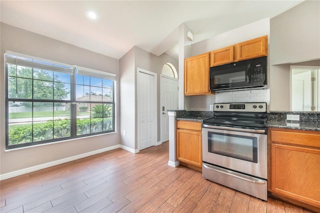 161 Oak Crossing Blvd, Auburndale, FL 33823 - kitchen with black microwave, electric range, tasteful backsplash, light wood-type flooring, and dark stone counters