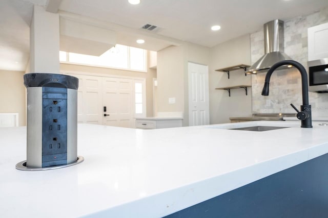 809 59th Ave, Saint Petersburg, FL 33706 - kitchen with stainless steel microwave, backsplash, wall chimney range hood, recessed lighting, and open shelves