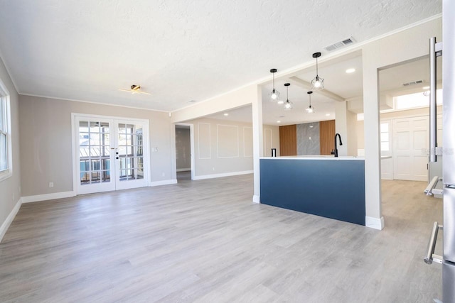 809 59th Ave, Saint Petersburg, FL 33706 - unfurnished living room with french doors, a textured ceiling, light wood finished floors, and crown molding