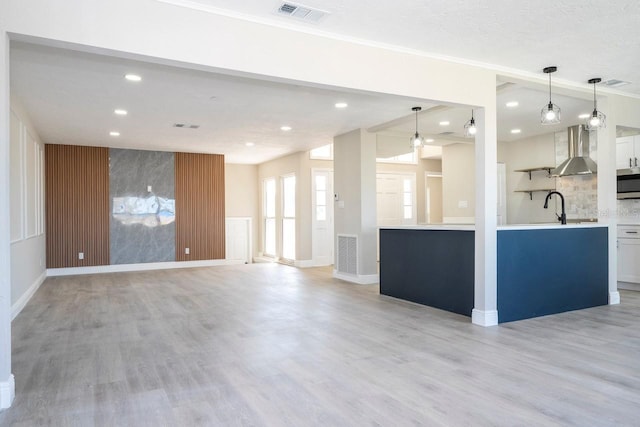 809 59th Ave, Saint Petersburg, FL 33706 - unfurnished living room with light wood-type flooring, recessed lighting, and crown molding