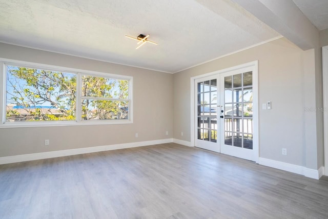 809 59th Ave, Saint Petersburg, FL 33706 - spare room featuring french doors, plenty of natural light, wood finished floors, and crown molding