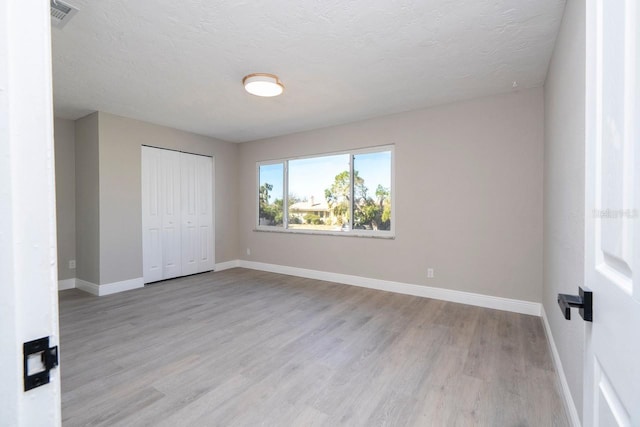809 59th Ave, Saint Petersburg, FL 33706 - unfurnished bedroom featuring light wood finished floors, a closet, and a textured ceiling