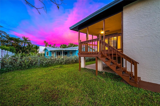 809 59th Ave, Saint Petersburg, FL 33706 - yard at dusk featuring stairs, ceiling fan, and a wooden deck