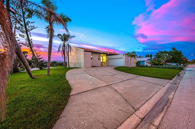 809 59th Ave, Saint Petersburg, FL 33706 - view of front of home featuring driveway, a lawn, stucco siding, and a garage